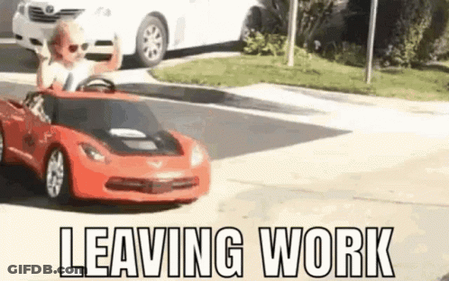 A Little Boy Is Driving A Red Toy Car On A Street . GIF