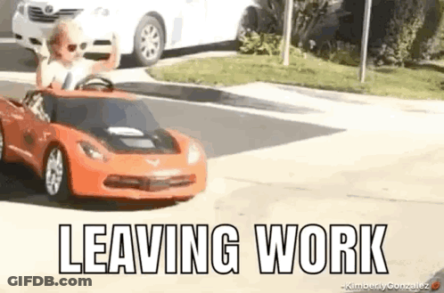 A Little Boy Is Driving A Toy Car Down A Street And Waving . GIF