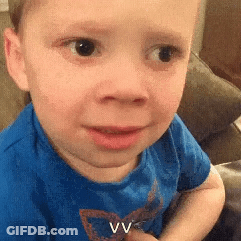 A Little Boy Is Making A Funny Face While Sitting On A Couch . GIF