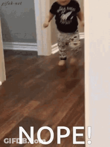 A Little Boy Is Running Through A Hallway And The Word Nope Is Written On The Floor . GIF