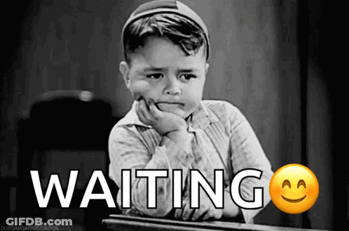 A Little Boy Is Sitting At A Desk With The Word Waiting Written On The Bottom GIF