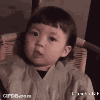 A Little Boy Is Sitting In A Chair And Making A Face . GIF