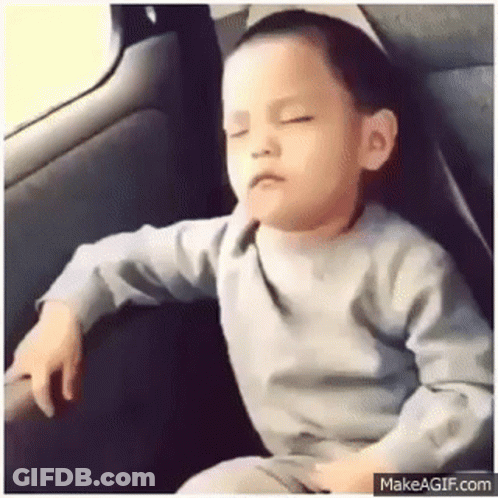 A Little Boy Is Sitting In The Back Seat Of A Car . GIF