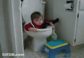 A Little Boy Is Sitting On A Toilet Next To A Toy Stool GIF