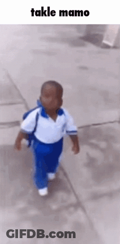 A Little Boy Is Walking Down A Sidewalk With A Backpack On His Back . GIF