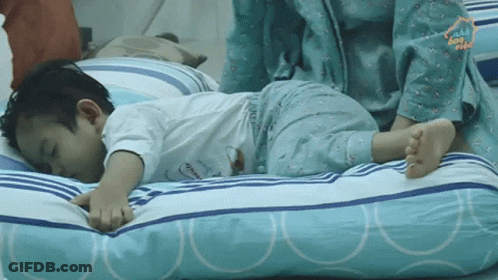 A Little Boy Laying On A Pillow With The Word Home On The Bottom Right GIF
