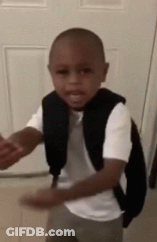 A Little Boy Wearing A Backpack Is Standing In Front Of A Door . GIF