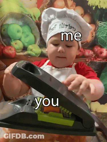 A Little Boy Wearing A Chef 'S Hat And Apron Is Using A Slicer GIF