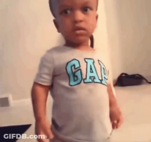 A Little Boy Wearing A Gap T-Shirt Is Standing In A Room . GIF