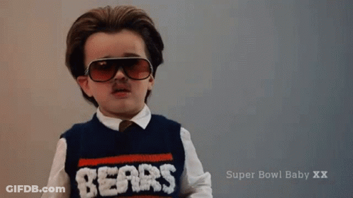 A Little Boy Wearing Sunglasses And A Sweater That Says Nerds On It GIF