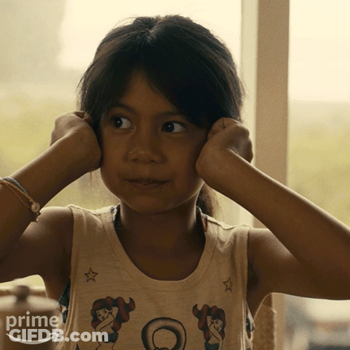 A Little Girl Covering Her Ears With Her Hands And A Shirt That Says Prime On It GIF