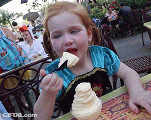 A Little Girl Eating Ice Cream With A Spoon GIF