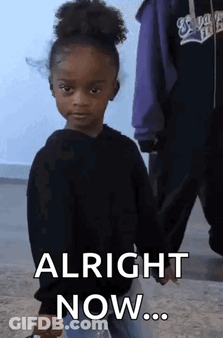 A Little Girl In A Black Sweater Is Holding A Bottle Of Water And Says Alright Now . GIF
