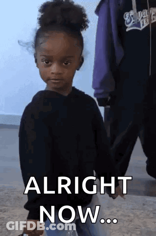 A Little Girl In A Black Sweater Is Holding A Bottle Of Water And Says Alright Now . GIF