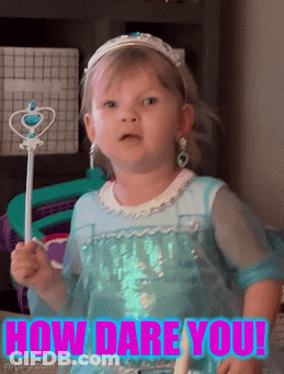 A Little Girl In A Blue Dress Is Holding A Wand With The Words How Dare You Written On It GIF