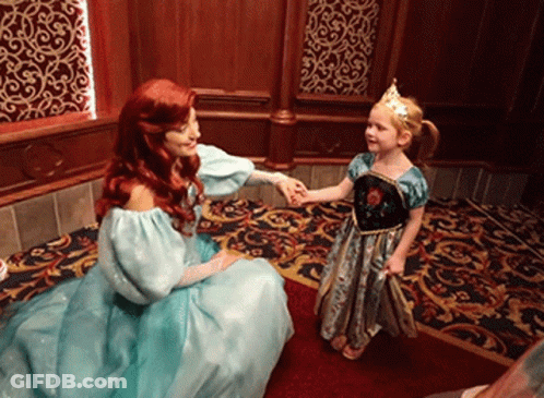 A Little Girl In A Blue Dress Is Holding Hands With A Princess GIF