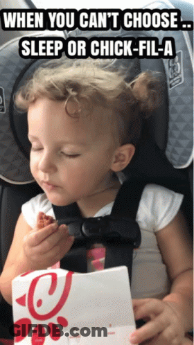 A Little Girl In A Car Seat Eating A Piece Of Chicken GIF