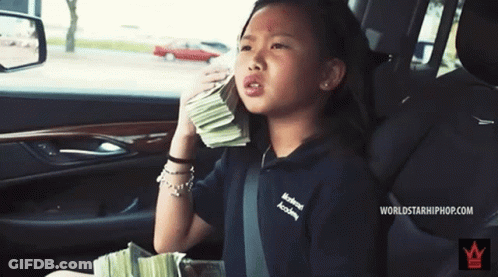 A Little Girl In A Car With A Stack Of Money GIF