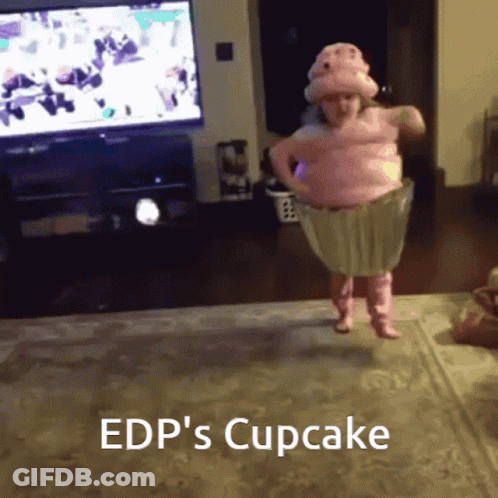 A Little Girl In A Pink Cupcake Costume Is Jumping In The Air GIF