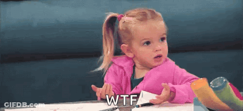 A Little Girl In A Pink Jacket Is Sitting At A Table Holding A Piece Of Paper And Making A Funny Face . GIF