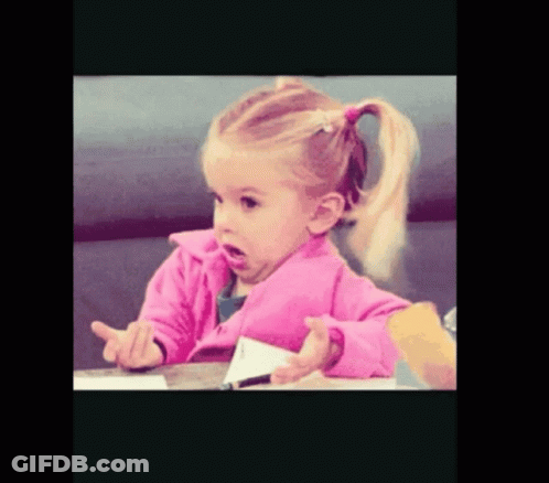 A Little Girl In A Pink Jacket Sitting At A Table GIF