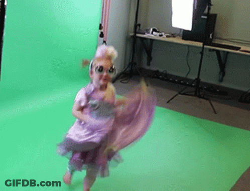 A Little Girl In A Purple Dress Is Dancing In Front Of A Green Background GIF
