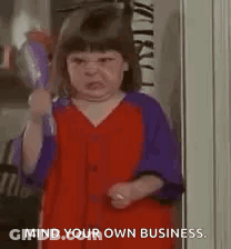 A Little Girl In A Red And Purple Dress Is Holding A Hair Dryer In Her Hand . GIF