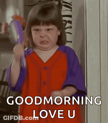 A Little Girl In A Red And Purple Dress Is Holding A Tambourine And Making A Funny Face . GIF