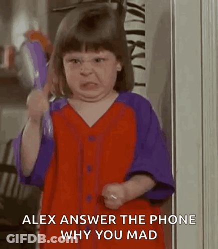 A Little Girl In A Red And Purple Shirt Is Making A Funny Face While Holding A Toy . GIF