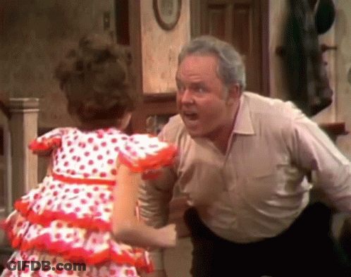 A Little Girl In A Red And White Polka Dot Dress Is Standing Next To A Man In A White Shirt . GIF