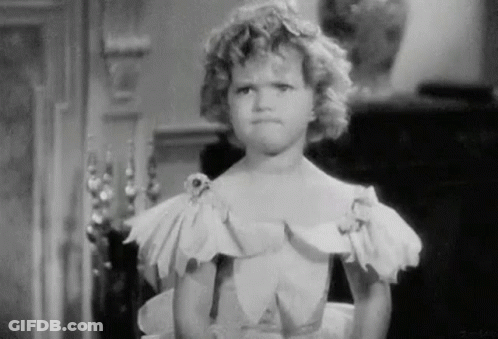 A Little Girl In A White Dress Is Making A Funny Face . GIF