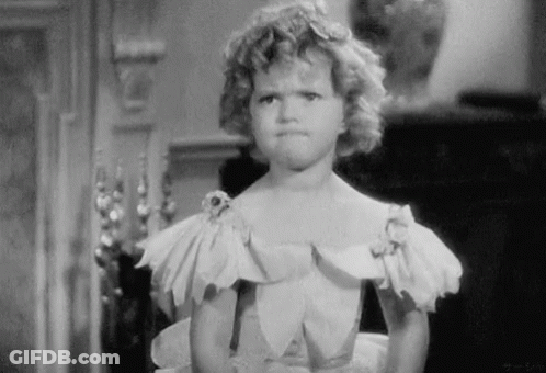 A Little Girl In A White Dress Is Making A Funny Face GIF