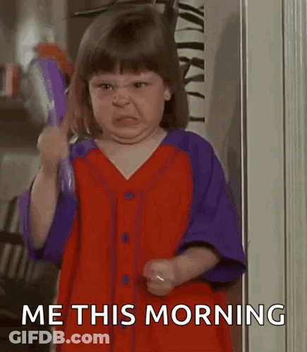 A Little Girl Is Brushing Her Hair With A Brush And Making A Face . GIF