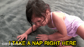 A Little Girl Is Crawling On The Sand With The Words " I Take A Nap Right Here " Below Her GIF