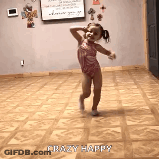 A Little Girl Is Dancing In A Room With A Wooden Floor . GIF