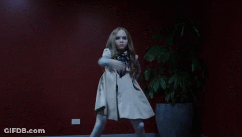 A Little Girl Is Dancing In Front Of A Potted Plant GIF