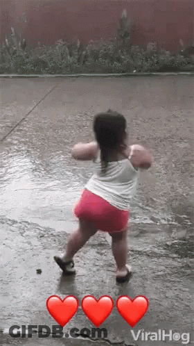 A Little Girl Is Dancing In The Rain With Three Red Hearts . GIF