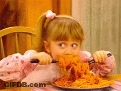 A Little Girl Is Eating A Plate Of Spaghetti With A Fork GIF