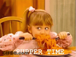 A Little Girl Is Eating Spaghetti With The Words Supper Time Written On The Bottom Right GIF