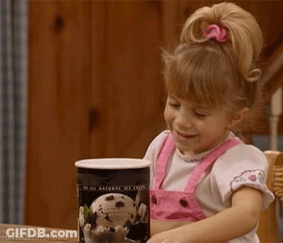 A Little Girl Is Holding A Can Of Ice Cream And Smiling GIF