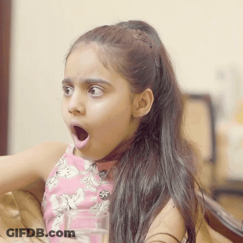 A Little Girl Is Holding A Glass Of Water With Her Mouth Open GIF