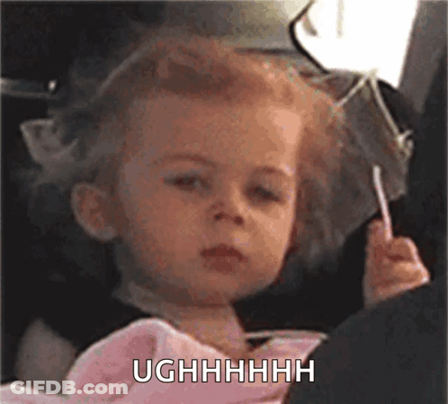 A Little Girl Is Holding A Lollipop In Her Hand And Making A Funny Face . GIF