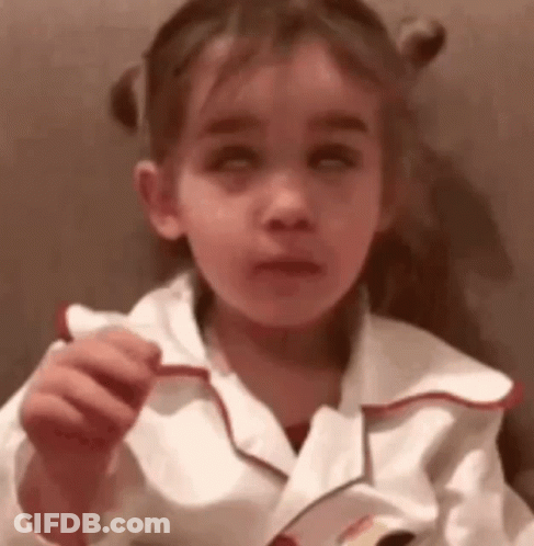 A Little Girl Is Holding A Piece Of Paper In Her Hand And Making A Face . GIF