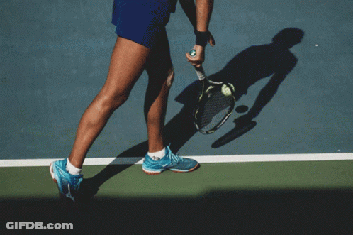 A Little Girl Is Holding A Tennis Racquet And A Tennis Ball GIF