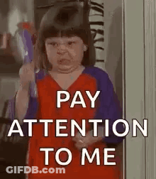 A Little Girl Is Holding A Toy Gun And Making A Funny Face While Saying `` Pay Attention To Me '' . GIF