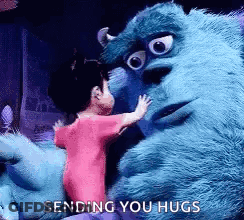 A Little Girl Is Hugging A Stuffed Animal From Monsters Inc . GIF