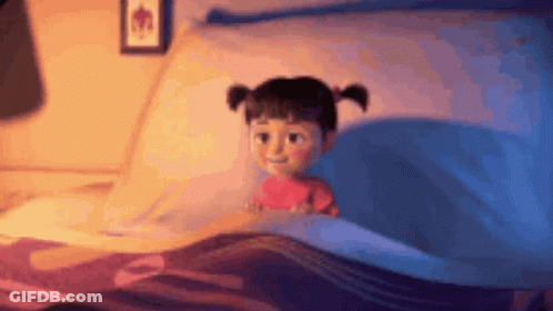 A Little Girl Is Laying In A Bed With A Blue Blanket And A Picture On The Wall . GIF