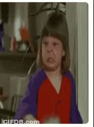 A Little Girl Is Making A Funny Face In A Kitchen . GIF