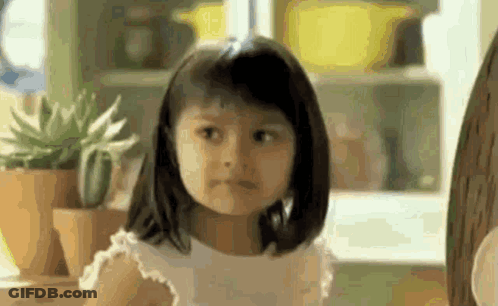 A Little Girl Is Making A Funny Face In Front Of A Window . GIF