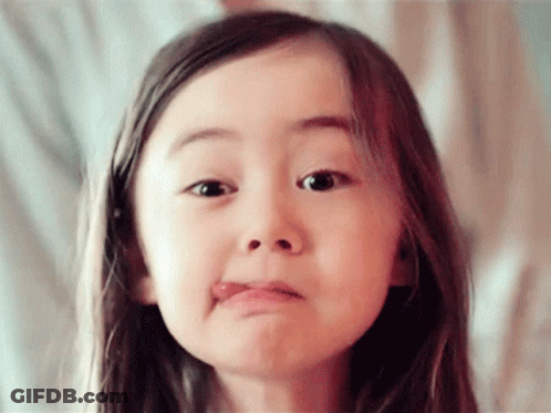 A Little Girl Is Making A Funny Face With Her Tongue Out GIF